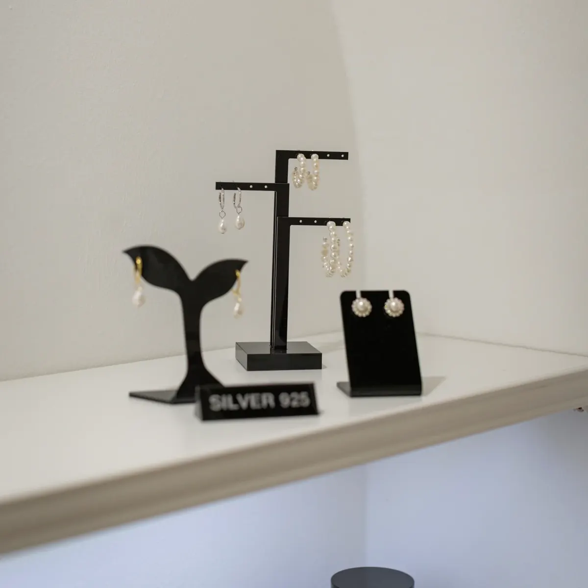 Silberne Ohrringe auf Ständern in der Vitrine des neelia-Ladens