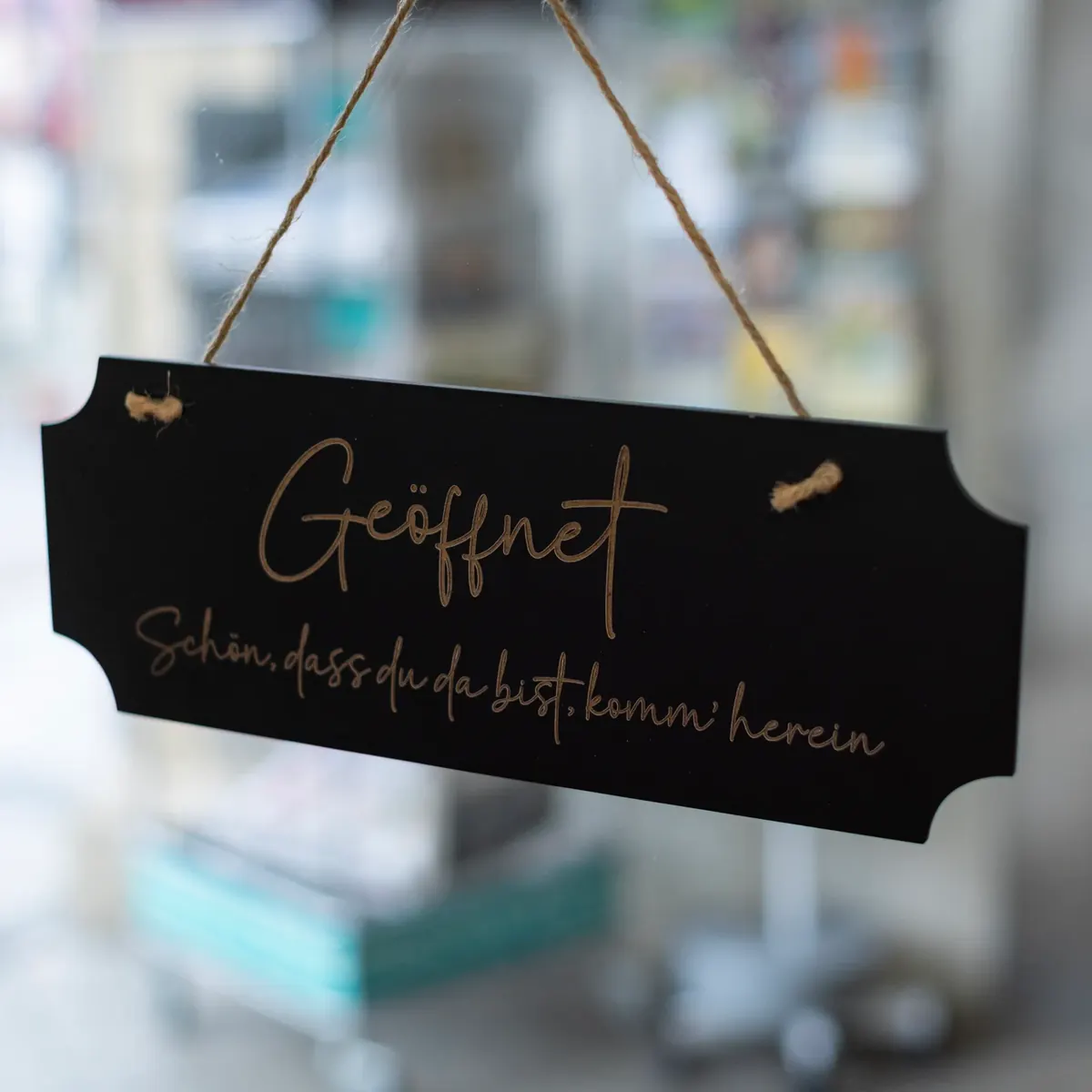 Schild an der Ladentür: Geöffnet, schön, dass du da bist, komm herein